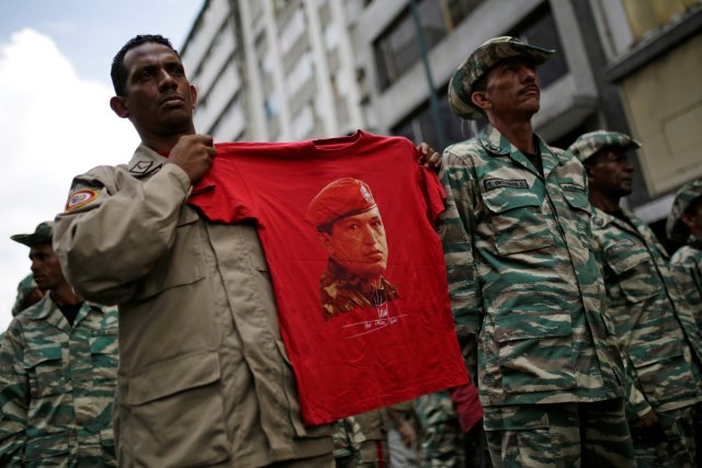 A militia member holds a t-shirt with an image of Venezuela's late President Hugo Chavez during a ceremony with Venezuela's President Nicolas Maduro at Miraflores Palace in Caracas, Venezuela April 17, 2017. REUTERS/Marco Bello