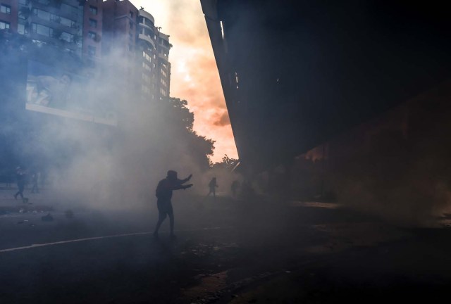 Anti-government protesters block the Francisco Fajardo highway in Caracas during a demonstration against Venezuelan President Nicolas Maduro on May 27, 2017. Demonstrations that got underway in late March have claimed the lives of 58 people, as opposition leaders seek to ramp up pressure on Venezuela's leftist president, whose already-low popularity has cratered amid ongoing shortages of food and medicines, among other economic woes. / AFP PHOTO / JUAN BARRETO