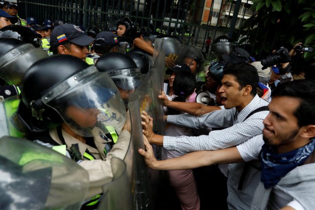 Los partidarios de la oposición se enfrentaron a las fuerzas de seguridad el viernes, mientras protestaban contra el presidente Nicolás Maduro en Caracas, Venezuela. Credit Carlos Garcia Rawlins / Reuters