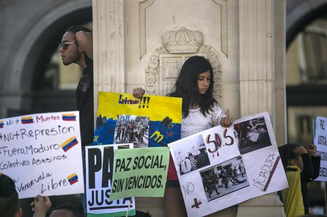 Casi un millar de opositores al gobierno venezolano se han concentrado hoy en la madrileña Plaza de Isabel II para solicitar a la comunidad internacional una mayor condena al presidente de su país Nicolás Maduro. EFE/Santi Donaire