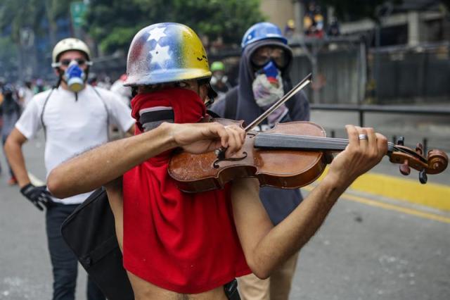 Un manifestante toca violín en una manifestación hoy, lunes 8 de mayo de 2017, en Caracas (Venezuela).  Foto: EFE/CRISTIAN HERNÁNDEZ