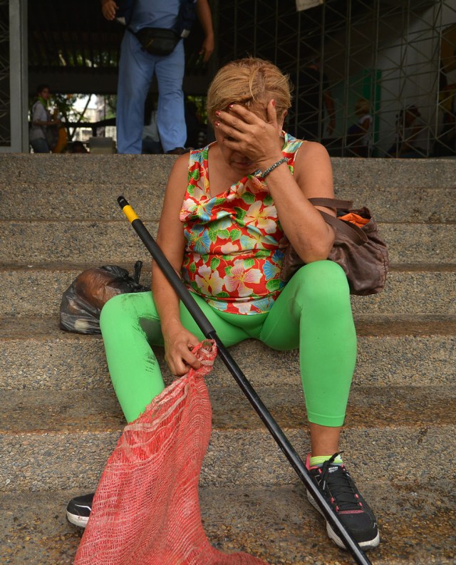 An opposition demonstrator is affected by tear gas in clashes with the riot police during the "Towards Victory" protest against the government of Nicolas Maduro, in Caracas on June 10, 2017.  Clashes at near daily protests by demonstrators calling for Maduro to quit have left 66 people dead since April 1, prosecutors say.  / AFP PHOTO / LUIS ROBAYO