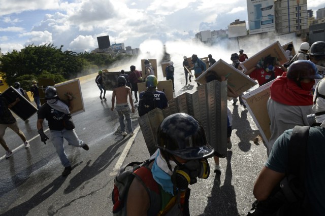 Opposition demonstrators clash with riot police during the "Towards Victory" protest against the government of Nicolas Maduro, in Caracas on June 10, 2017.  Clashes at near daily protests by demonstrators calling for Maduro to quit have left 66 people dead since April 1, prosecutors say.  / AFP PHOTO / FEDERICO PARRA