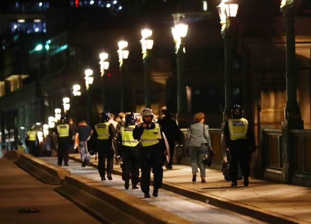 Police officers cross Southwark Bridge after an incident near London Bridge in London, Britain June 4, 2017. REUTERS/Neil Hall