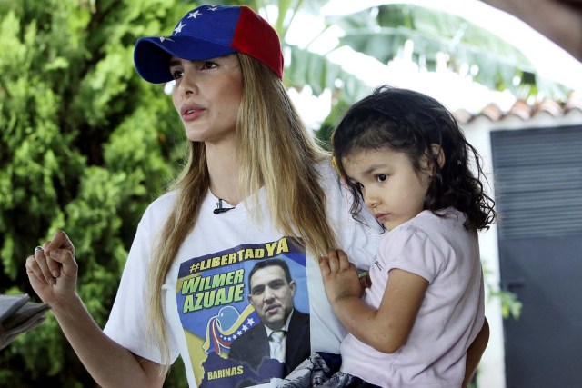 Kelly Garcia, wife of the opposition lawmaker Wilmer Azuaje, carrying her daughter, speaks during an interview with Reuters in Barinas, Venezuela June 12, 2017. Picture taken June 12, 2017. REUTERS/Carlos Eduardo Ramirez