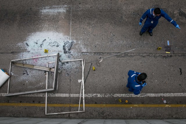 CAR26. CARACAS (VENEZUELA), 08/06/2017 - Trabajadores del Ministerio Público realizan hoy, jueves 8 de junio de 2017, el levantamiento planimétrico en el lugar en el que un joven de 17 años murió durante una protesta opositora, en Caracas (Venezuela). El Ministerio Público venezolano (MP, Fiscalía) cifró hoy en 67 las muertes registradas en hechos violentos relacionados con las protestas a favor y en contra del Gobierno de Nicolás Maduro que sacuden la nación desde hace 69 días. EFE/MIGUEL GUTIÉRREZ