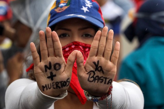 CAR32. CARACAS (VENEZUELA), 24/06/2017.- Una mujer muestra un mensaje escrito en las palmas de sus manos durante una manifestación denominada "Venezuela le da un mensaje a la FAN (Fuerza Armada)" hoy, sábado 24 de junio de 2017, en Caracas (Venezuela). La oposición venezolana se moviliza hoy hasta las bases militares en Caracas y varios estados del país, mientras el chavismo marcha para conmemorar los 196 años de la Batalla de Carabobo, una acción militar decisiva en la independencia del país caribeño, y por el Día del Ejército Bolivariano. EFE/Miguel Gutiérrez