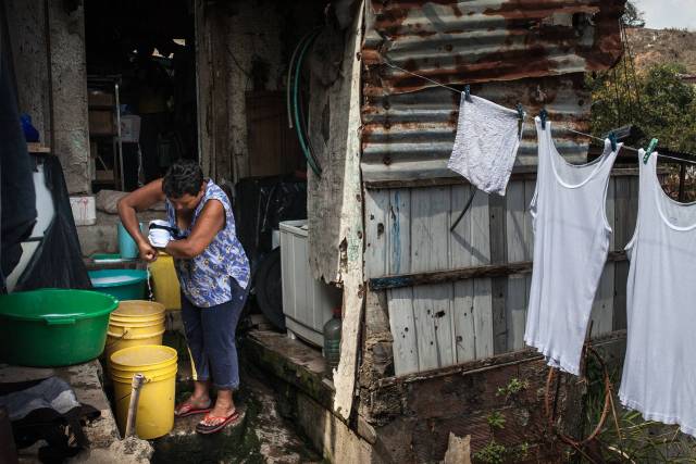 Una mujer lava la ropa en su casa en un barrio pobre de Caracas, 17 de marzo de 2016. El área recibe el servicio regular de agua una vez por semana. FOTO: WIL RIERA PARA THE WALL STREET JOURNAL