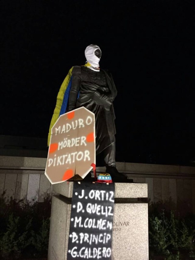 La estatua de Simón Bolívar en Berlin cubierta con capucha, bandera, y carteles denunciando la represiónn en Venezuela 