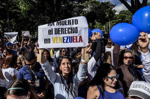 General Prosecutor's office employees demonstrate in support of Attorney General Luisa Ortega in Caracas on June 19 , 2017.   Venezuela's Supreme Court on Friday rejected a bid to put on trial several senior judges accused of favoring embattled President Nicolas Maduro as he clings to power in the face of deadly unrest. / AFP PHOTO / JUAN BARRETO