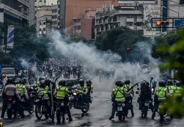 Los activistas de la oposición chocan con la policía antidisturbios durante una demo en Caracas el 7 de junio de 2017. El jefe del Ejército venezolano, general Vladimir Padrino López, quien también es ministro de Defensa del presidente Nicolas Maduro, está advirtiendo a sus tropas que no cometan "atrocidades" contra los manifestantes que se manifiestan en la mortífera crisis política del país. La advertencia del martes se produjo después de más de dos meses de violentos enfrentamientos entre manifestantes y fuerzas de seguridad. La oposición y un grupo de defensa de prensa dicen que las fuerzas de seguridad han atropellado, atacado y robado a manifestantes y periodistas. / AFP FOTO / JUAN BARRETO