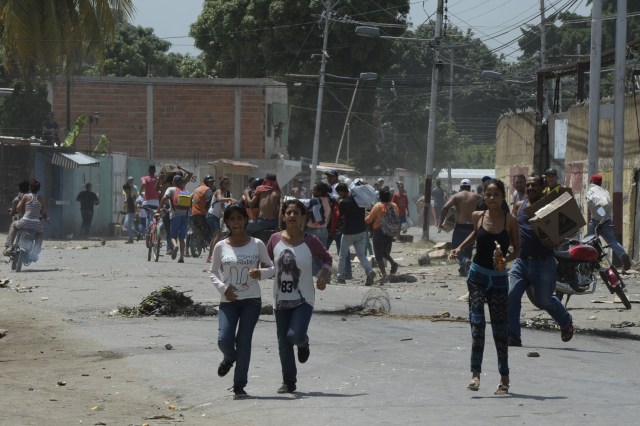 Locales que llevan mercancía robada durante saqueos en Maracay, estado de Aragua, Venezuela el 27 de junio de 2017. / AFP PHOTO / Federico Parra