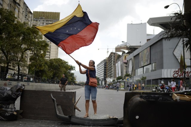 Venezuelan opposition activists protest in Caracas on July 10, 2017. Venezuela hit its 100th day of anti-government protests Sunday, amid uncertainty over whether the release from prison a day earlier of prominent political prisoner Leopoldo Lopez might open the way to negotiations to defuse the profound crisis gripping the country. / AFP PHOTO / FEDERICO PARRA