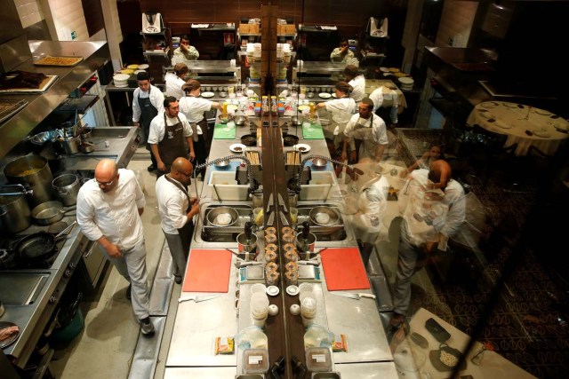 Chef Carlos Garcia (L) and his crew, work within the kitchen of the Alto restaurant in Caracas, Venezuela June 29, 2017. Picture taken June 29, 2017. REUTERS/Ivan Alvarado