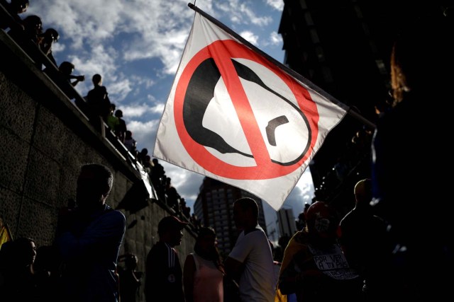 Opposition supporters carry a flag with a cartoon of Venezuela's President Nicolas Maduro while attending a rally to pay tribute to victims of violence during protests against Maduro's government in Caracas, Venezuela, July 24, 2017. REUTERS/Ueslei Marcelino NO RESALES. NO ARCHIVES TPX IMAGES OF THE DAY