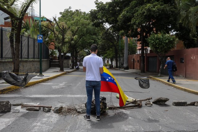 CAR17. CARACAS (VENEZUELA), 10/07/2017.- Un manifestante participa en un "trancazo" hoy, lunes 10 de julio de 2017, en Caracas (Venezuela). Los opositores venezolanos atendieron hoy a la convocatoria de realizar un "trancazo" de calles en todo el país contra la "dictadura" que se espera se extienda por diez horas, después de que la alianza antichavista intentara reducir esta protesta a solo dos horas. EFE/Miguel Gutiérrez