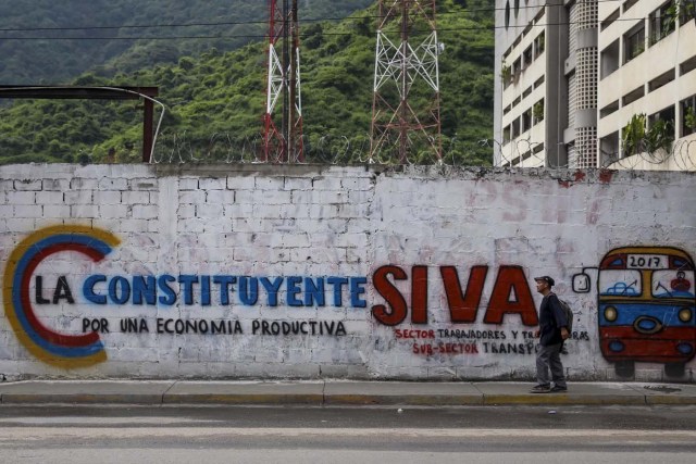 ACOMPAÑA CRÓNICA: VENEZUELA CRISIS - CAR006. CARACAS (VENEZUELA), 15/07/2017.- Un hombre camina junto a una pared decorada con propaganda de la Asamblea Nacional Constituyente hoy, sábado 15 de julio de 2017, en Caracas (Venezuela). Con el éxito asegurado en las zonas privilegiadas de Caracas, donde el chavismo nunca tuvo predicamento, la consulta opositora sobre la Asamblea Constituyente que impulsa el presidente Nicolás Maduro se la juega ahora en los barrios populares que vieron en Hugo Chávez el mesías de la Revolución Bolivariana. EFE/Miguel Gutiérrez