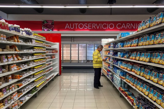 CAR24. CARACAS (VENEZUELA), 24/07/2017.- Personas buscan alimentos en un supermercado con estanterías con alimentos repetidos hoy, lunes 24 de julio de 2017, en Caracas (Venezuela). Numerosos supermercados de Caracas cerrarán hoy con más estanterías vacías de lo habitual después de que los habitantes de la capital hicieran acopio de alimentos y otros productos básicos ante el paro general contra el Gobierno que la oposición convocó para el miércoles y el jueves. EFE/MIGUEL GUTIÉRREZ