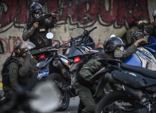 VENEZUELA-CRISIS-CONSTITUENT-ASSEMBLY-PROTEST Anti-government activists drag a police motorbike burnt after the explosion of an explosive device during a protest against the elections for a Constituent Assembly in Caracas on July 30, 2017. Deadly violence erupted around the controversial vote, with a candidate to the all-powerful body being elected shot dead and troops firing weapons to clear protesters in Caracas and elsewhere. Ronaldo SCHEMIDT / AFP