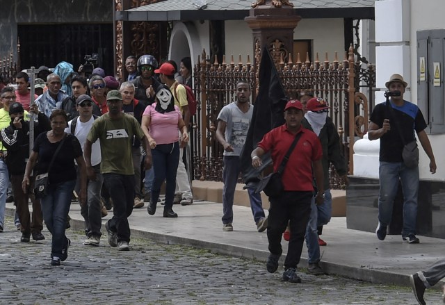 Supporters of Venezuelan President Nicolas Maduro storm the National Assembly building in Caracas on July 5, 2017 as opposition deputies hold a special session on Independence Day. A political and economic crisis in the oil-producing country has spawned often violent demonstrations by protesters demanding President Nicolas Maduro's resignation and new elections. The unrest has left 91 people dead since April 1. / AFP PHOTO / Juan BARRETO