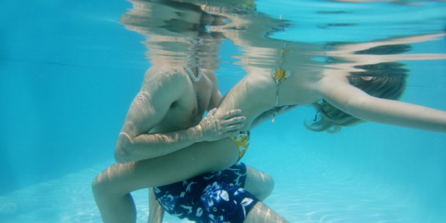 Cropped view of a couple holding each other in a pool