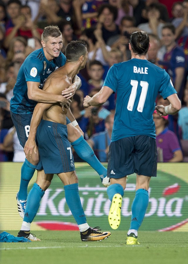 Real Madrid's Portuguese forward Cristiano Ronaldo (C) celebrates a goal with teammates Real Madrid's German midfielder Toni Kroos (L) and Real Madrid's Welsh forward Gareth Bale during the first leg of the Spanish Supercup football match between FC Barcelona and Real Madrid at the Camp Nou stadium in Barcelona, on August 13, 2017. / AFP PHOTO / Josep LAGO