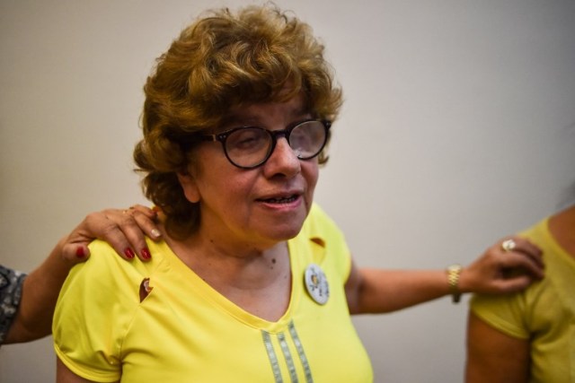 A woman with low vision attends a salsa dance class in Cali, Colombia, on August 13, 2017, during the eighth version of the "Tifloencuentro". 69 people with visual impairment from eight countries of Latin America and Europe take part in the "Tifloencuentro", a tourism event in which blind and people with low vision meet in a cultural exchange of life experiences. / AFP PHOTO / LUIS ROBAYO / TO GO WITH AFP STORY