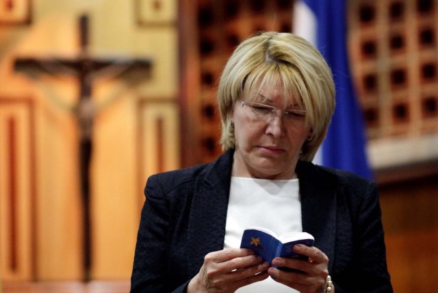 Venezuela's chief prosecutor Luisa Ortega Diaz looks at a copy of the Venezuelan Constitution during a conference in defense of the Constitution in Caracas, Venezuela August 6, 2017. REUTERS/Ueslei Marcelino