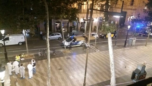 Forensic workers stand near a dead person at the scene after a van crashed into pedestrians near the Las Ramblas avenue in central Barcelona, Spain August 17, 2017. REUTERS/Giselle Loots   MANDATORY CREDIT. SPAIN OUT.