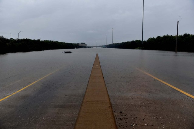 An abandoned vehicle is covered by flood waters on Interstate 610 after Hurricane Harvey inundated the Texas Gulf coast with rain, in Houston, Texas, U.S. August 27, 2017. REUTERS/Nick Oxford