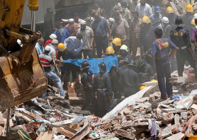 Firefighters and rescue workers remove the body of a victim from debris at the site of a collapsed building in Mumbai, India, August 31, 2017. REUTERS/Shailesh Andrade