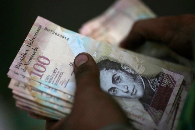 En la imagen de archivo una persona cuenta Bolivares venezolanos en un mercado de la calle del centro de Caracas, el 12 de ciembre de 2016. REUTERS/Ueslei Marcelino - RTX2UQIX