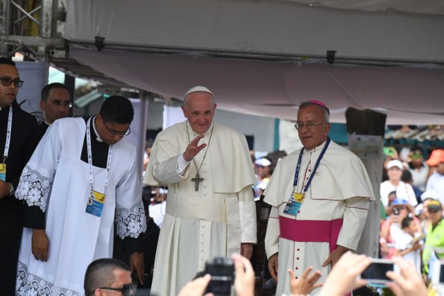 Pope Francis (C), flanked by Monsignor Jorge E.Rodriguez Carvajal (R), Archbishop of Cartagena, waves at the attendance during a ceremony on September 10, 2017 at San Francisco Square in Cartagena, Colombia. Nearly 1.3 million worshippers flocked to a mass by Pope Francis on Saturday in the Colombian city known as the stronghold of the late drug lord Pablo Escobar. / AFP PHOTO / Luis Acosta