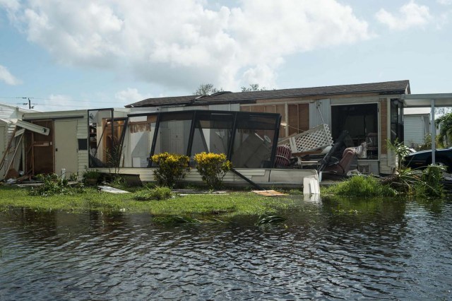 A damaged house is seen in a flooded street at the Enchanted Shores manufactured home park in Naples, Florida, on September 11, 2017 after Hurricane Irma hit Florida. / AFP PHOTO / NICHOLAS KAMM