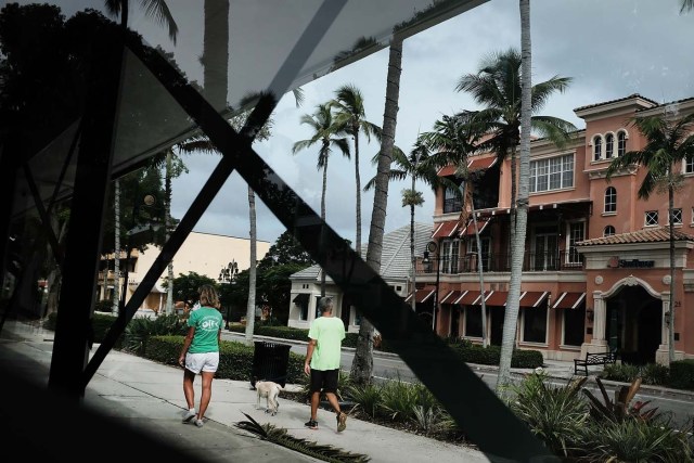 NAPLES, FL - SEPTEMBER 09: People walk through an empty downtown downtown Naples before the arrival of Hurricane Irma into Southwest Florida on September 9, 2017 in Naples, Florida. The Naples area could begin to feel hurricane-force winds from Irma by 11 a.m. Sunday and experience wind gusts over 100 mph from Sunday through Monday.   Spencer Platt/Getty Images/AFP