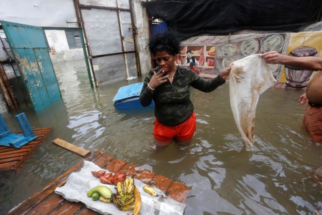 A woman receives a cloth after arranging produce on a piece of floating wood, after the passing of Hurricane Irma, in Havana, Cuba September 10, 2017. REUTERS/Stringer NO SALES. NO ARCHIVES