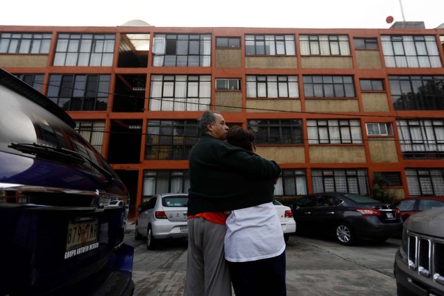 A man hugs his wife inside a residential area after a tremor was felt in Mexico City, Mexico, September 23, 2017. REUTERS/Edgard Garrido