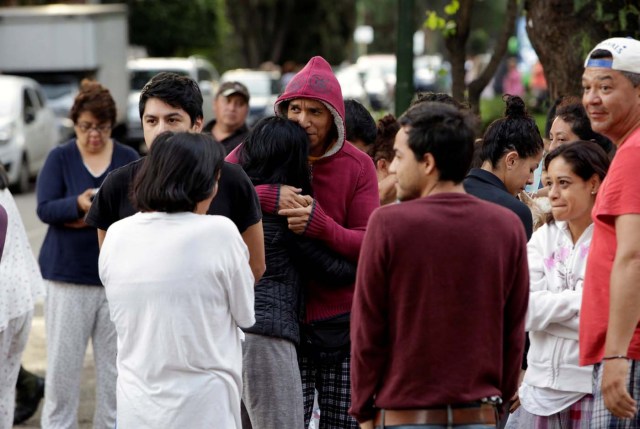 People stand together on a street after a tremor was felt in Mexico City, Mexico September 23, 2017. REUTERS/Jose Luis Gonzalez