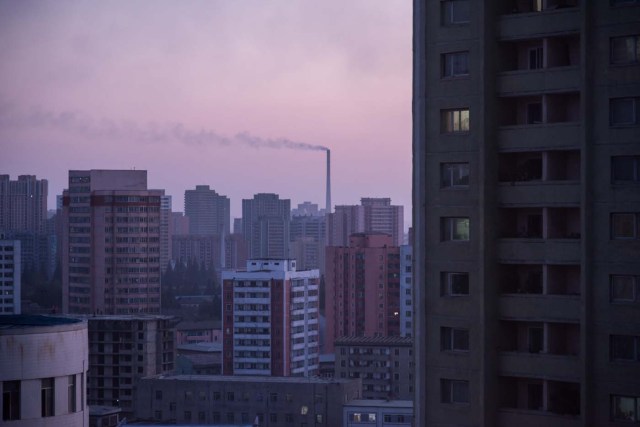 This photo taken on September 21, 2017 shows smoke billowing from a power station behind the skyline of Pyongyang. North Korea suffers from perennial energy shortages, epitomised by satellite photos of the country at night, showing it as a largely dark quadrilateral between the bright lights of China and the South. / AFP PHOTO / Ed JONES / TO GO WITH NKorea-economy-electricity-politics,FOCUS by Sebastien BERGER