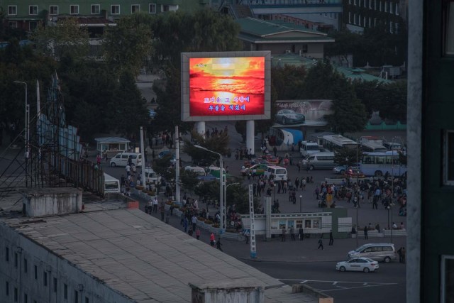 A photo taken on September 23, 2017 shows an image of the sun broadcast on the illuminated screen of a giant television in a public square in Pyongyang. North Korea suffers from perennial energy shortages, epitomised by satellite photos of the country at night, showing it as a largely dark quadrilateral between the bright lights of China and the South. / AFP PHOTO / Ed JONES / TO GO WITH: NKorea-economy-electricity-politics, FOCUS by Sebastien BERGER