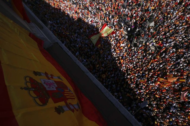 Protesters hold Spanish and Catalan flags during a demonstration called by "Societat Civil Catalana" (Catalan Civil Society) to support the unity of Spain on October 8, 2017 in Barcelona. Spain braced for more protests despite tentative signs that the sides may be seeking to defuse the crisis after Madrid offered a first apology to Catalans injured by police during their outlawed independence vote. / AFP PHOTO / PAU BARRENA