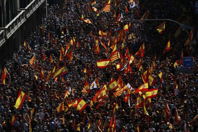 Protesters hold Spanish flags during a demonstration called by "Societat Civil Catalana" (Catalan Civil Society) to support the unity of Spain on October 8, 2017 in Barcelona. Spain braced for more protests despite tentative signs that the sides may be seeking to defuse the crisis after Madrid offered a first apology to Catalans injured by police during their outlawed independence vote. / AFP PHOTO / PAU BARRENA