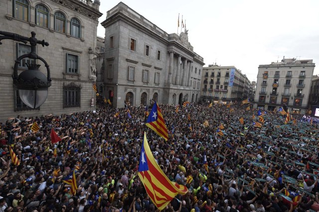 People gather to celebrate the proclamation of a Catalan republic at the Sant Jaume square in Barcelona on October 27, 2017.  Catalonia's parliament voted to declare independence from Spain and proclaim a republic, just as Madrid is poised to impose direct rule on the region to stop it in its tracks. A motion declaring independence was approved with 70 votes in favour, 10 against and two abstentions, with Catalan opposition MPs walking out of the 135-seat chamber before the vote in protest at a declaration unlikely to be given official recognition.  / AFP PHOTO / LLUIS GENE