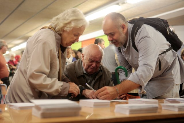 An old man reacts as he picks up a ballot inside a polling station for the banned separatist referendum in Barcelona, Spain October 1, 2017. REUTERS/Enrique Calvo