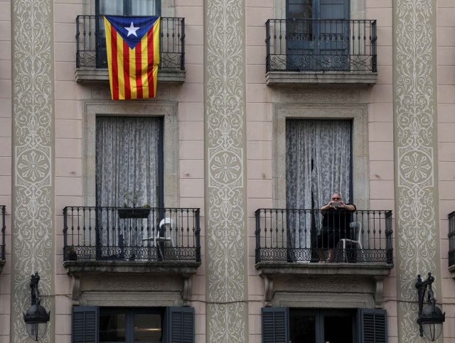 A woman takes a picture as people attend a protest called by pro-independence groups for citizens to gather at noon in front of city halls throughout Catalonia, in Plaza Sant Jaume in Barcelona, Spain October 2, 2017. REUTERS/Susana Vera