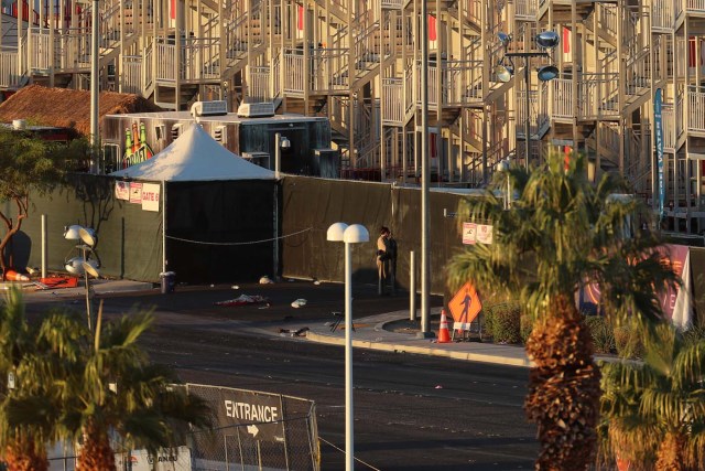 A police officer looks through a gate as she stands watch at the crime scene following the mass shooing at the Route 91 Harvest Country Music Festival on the Las Vegas Strip in Las Vegas, Nevada, U.S., October 3, 2017. REUTERS/Mike Blake