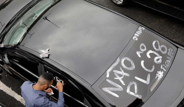 An Uber river paints his car during a protest against a legislation threatening the company's business model that is to be voted in Brazil's national congress, in Sao Paulo, Brazil October 30, 2017. REUTERS/Paulo Whitaker