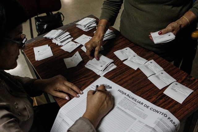 VEZ24. CARACAS (VENEZUELA), 15/10/2017.- Miembros de mesa y testigos participan en el cierre de mesas y auditoría de actas, en un centro electoral tras las elecciones regionales hoy, domingo 15 de octubre de 2017, en Caracas (Venezuela). La oposición venezolana, reunida en la Mesa de la Unidad Democrática (MUD), pidió hoy que se cierren los centros donde ya no haya electores para iniciar conteo y exigió que se mantengan abiertos aquellos donde aún haya gente en fila para votar, pues resaltó que esto está establecido en la ley. EFE/Cristian Hernández