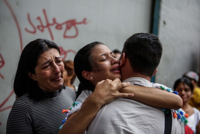 ACOMPAÑA CRÓNICA: VENEZUELA CRISIS - CAR02. CARACAS (VENEZUELA), 05/10/2018.- Fotografía del 29 de septiembre de 2017, que muestra a un joven (d) que se despide de su familia antes de abordar uno de los autobuses en Caracas (Venezuela) con destino a diferentes países suramericanos. La reducción de oferta y el alto costo de boletos aéreos internacionales han obligado a muchos venezolanos a migrar por vía terrestre a diferentes países de Suramérica en búsqueda de alimentos, salud, seguridad y un "futuro", un viaje que puede tomar entre día y medio y once días, dependiendo qué tan al sur quieran llegar. EFE/Cristian Hernández