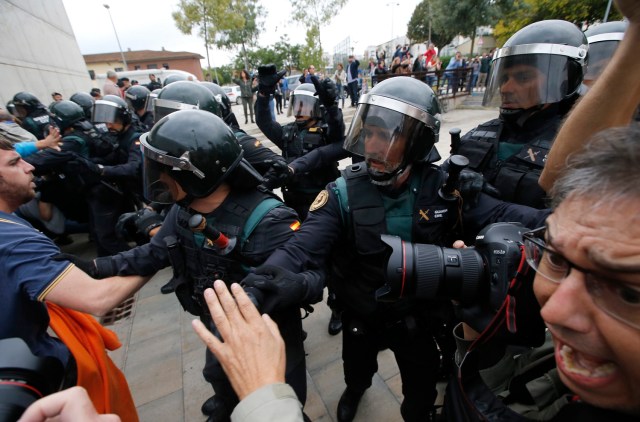 People clash with Spanish Guardia Civil guards outside a polling station in Sant Julia de Ramis, where Catalan president was supposed to vote, on October 1, 2017, on the day of a referendum on independence for Catalonia banned by Madrid. More than 5.3 million Catalans are called today to vote in a referendum on independence, surrounded by uncertainty over the intention of Spanish institutions to prevent this plebiscite banned by justice. / AFP PHOTO / Raymond ROIG